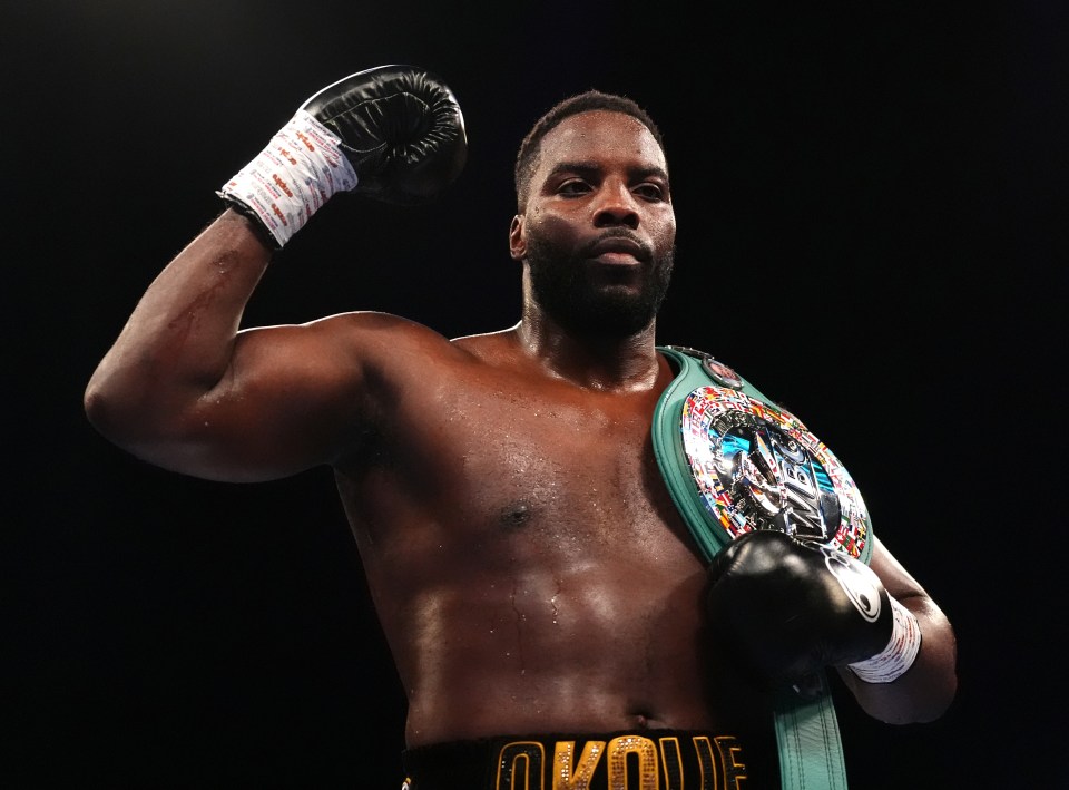 Lawrence Okolie celebrating a boxing victory, holding a championship belt.