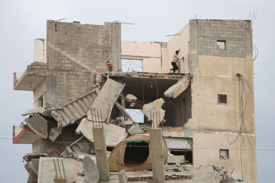 Palestinians walking through rubble-strewn streets in Gaza City following a ceasefire.