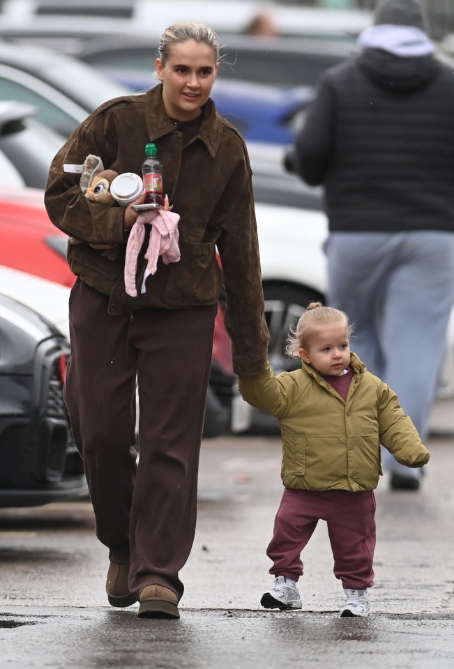 A woman and young child walking hand-in-hand.