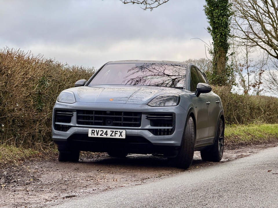 Gray Porsche Cayenne parked on a muddy road.