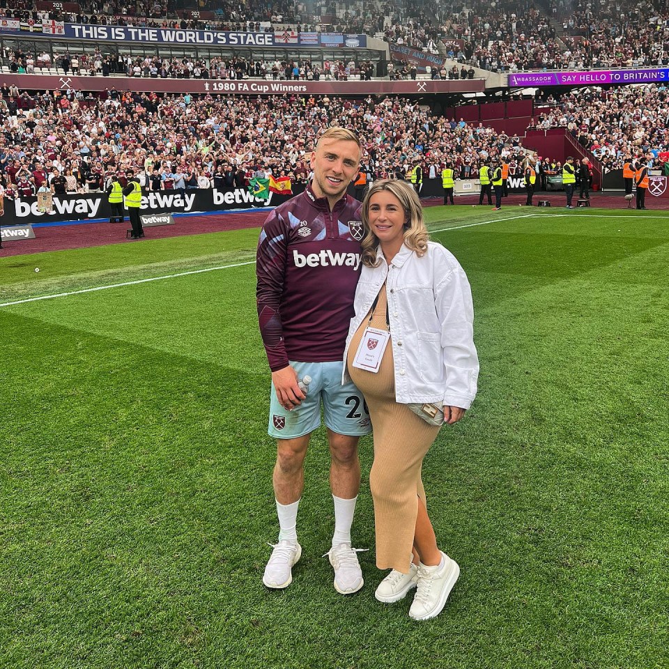Pregnant Dani Dyer and Jarrod Bowen on a soccer field.
