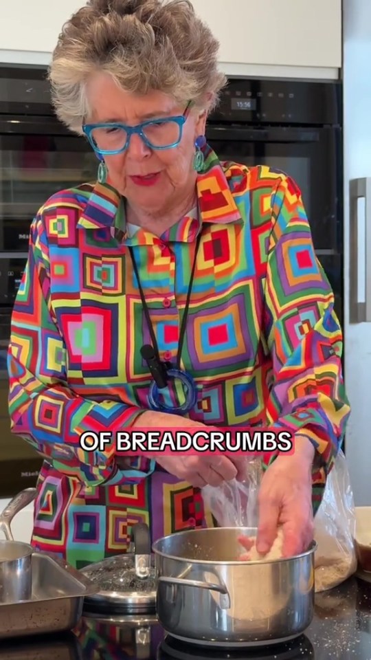 Prue Leith adding breadcrumbs to a pot.