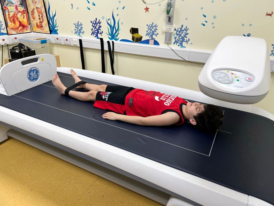 Boy lying on a bone density scanner.