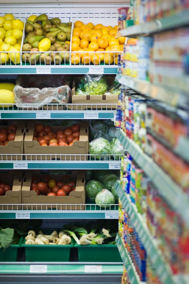Produce and canned goods on shelves in a grocery store.