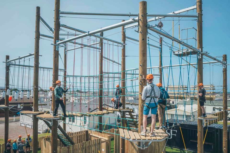 People navigating a high ropes course.