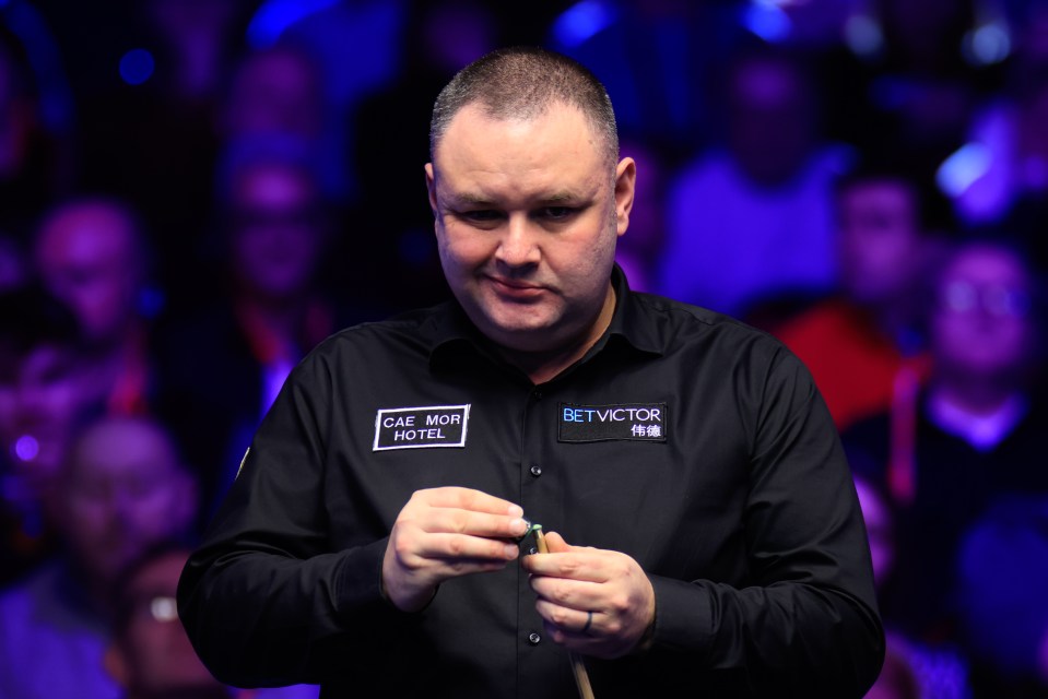 Stephen Maguire chalking his cue at a snooker match.