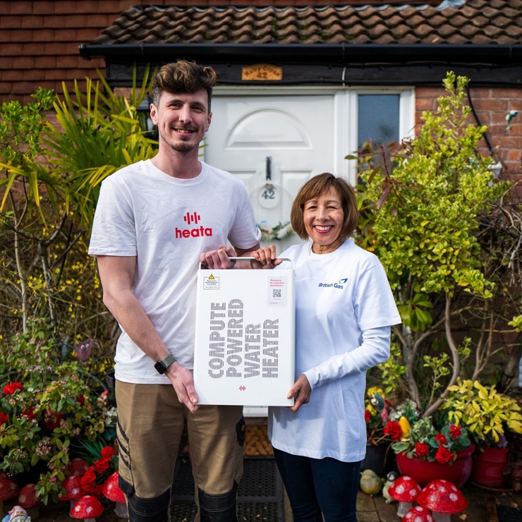 Two people holding a compute-powered water heater.