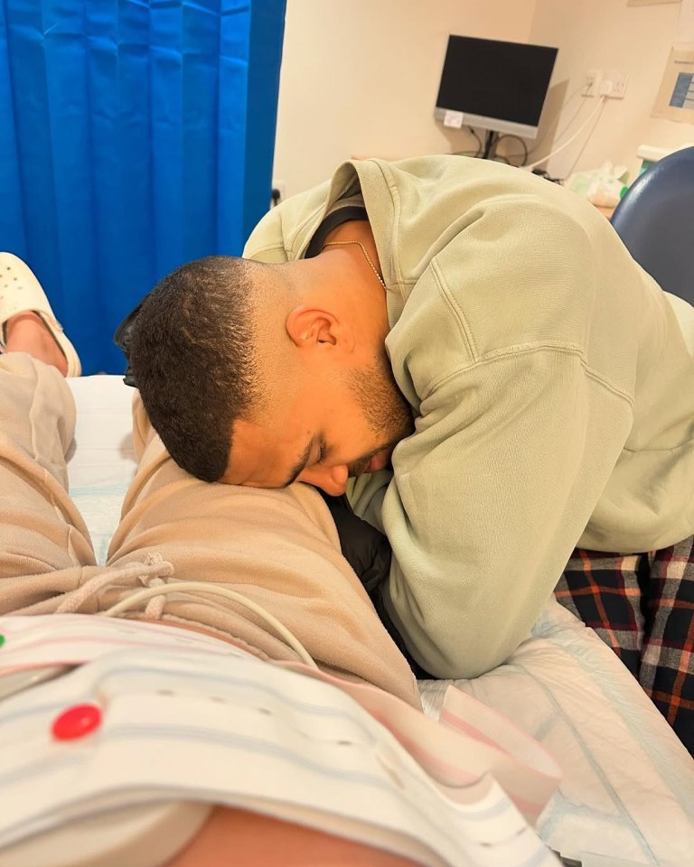 Man resting his head on a woman's stomach during labor.