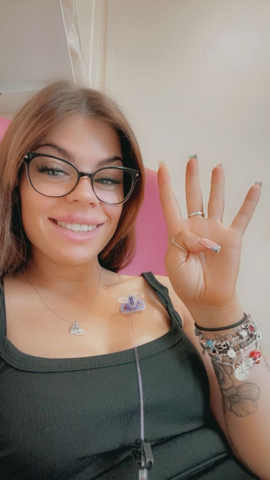 Woman holding up four fingers, indicating four rounds of chemotherapy.