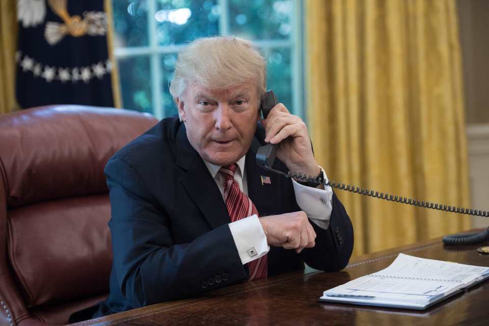 President Donald Trump on the phone in the Oval Office.