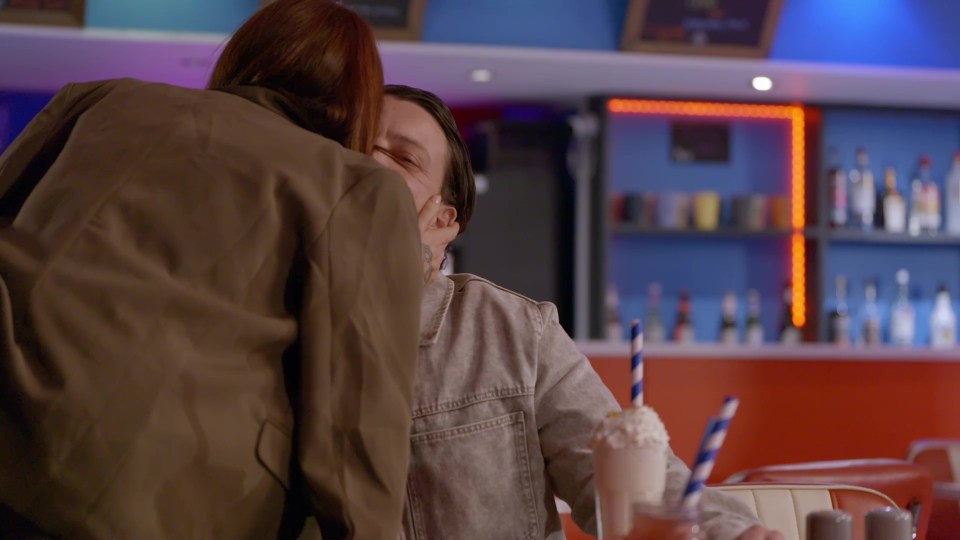 A woman embracing a man in a bar.