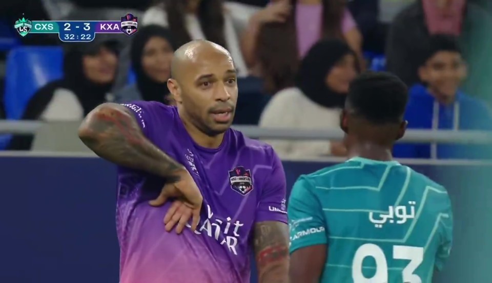 Thierry Henry playfully taunts an opponent during a soccer match.