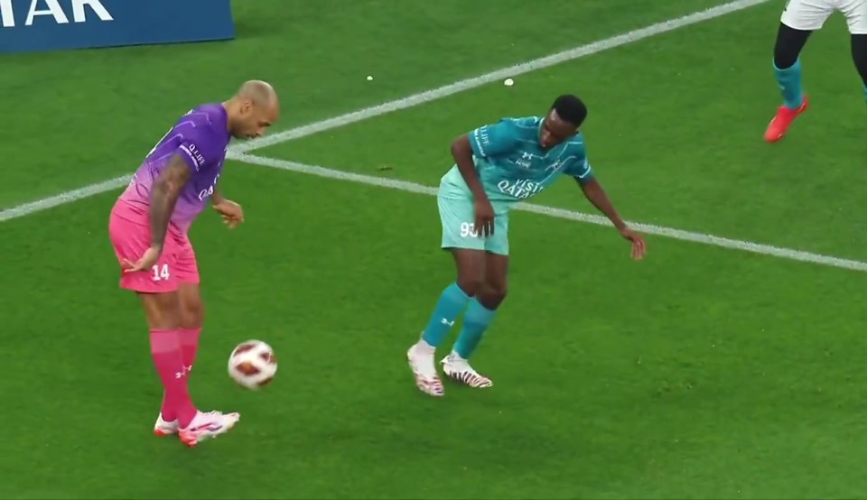 Thierry Henry skillfully dribbling the ball past an opponent during a soccer match.