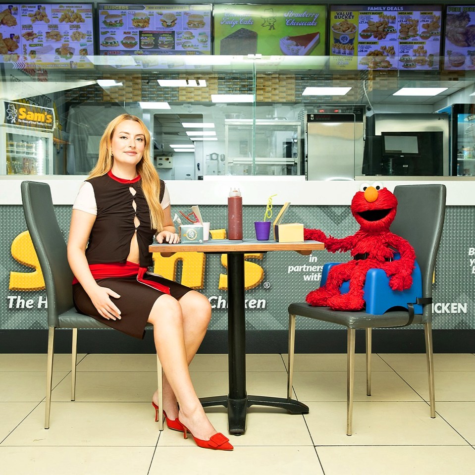 Amelia Dimoldenberg and Elmo at a Sam's Chicken restaurant.