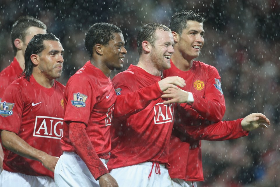 Manchester United players celebrating a goal in the rain.