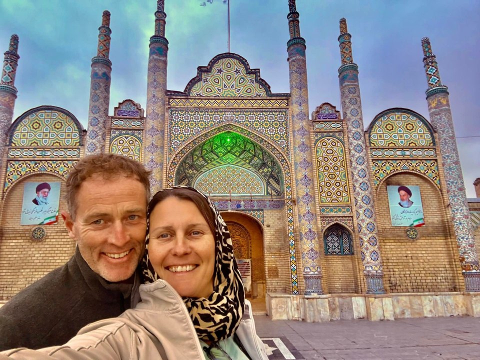 Couple taking a selfie in front of an ornate building in Iran.
