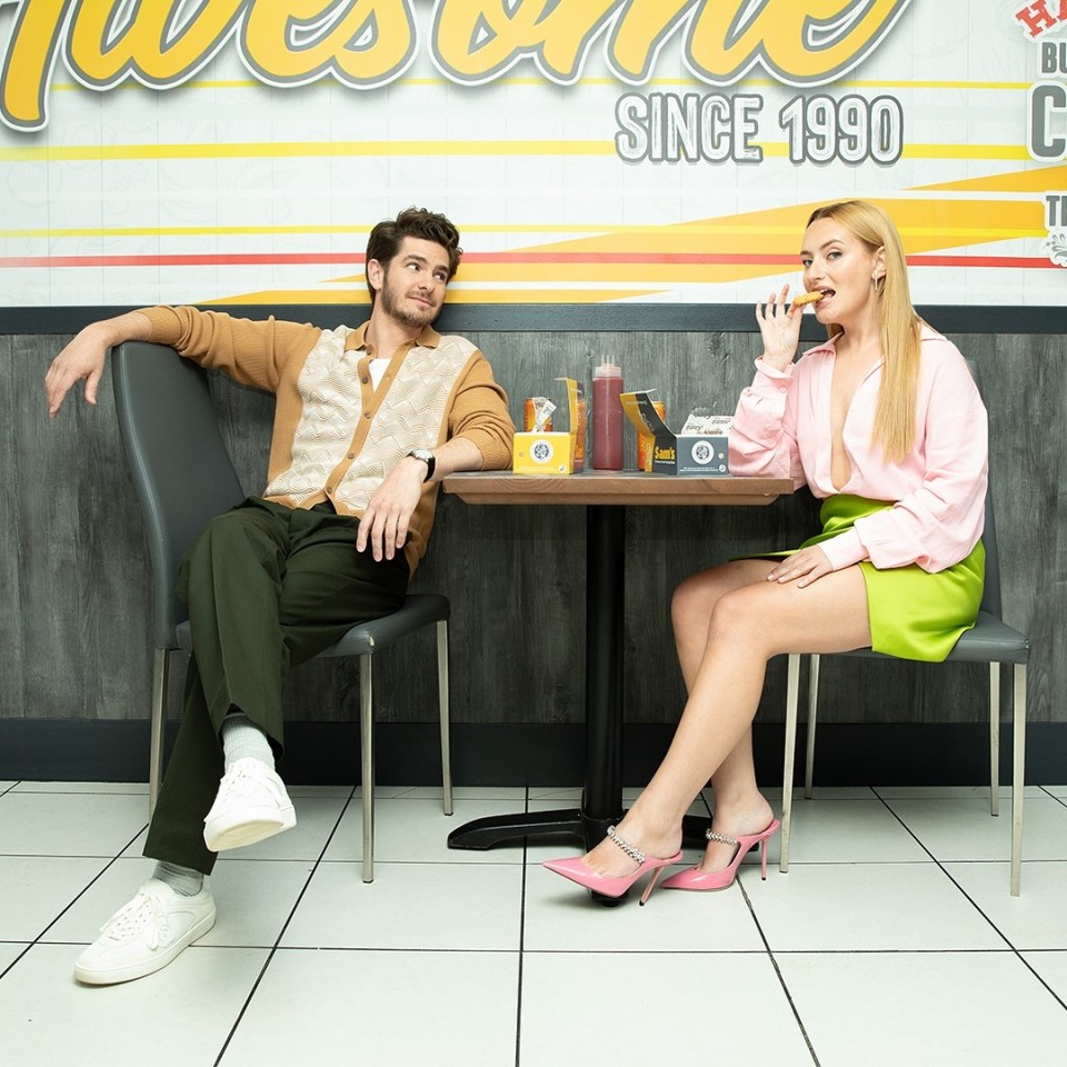 Andrew Garfield and Amelia Dimoldenberg sitting at a table in a restaurant.