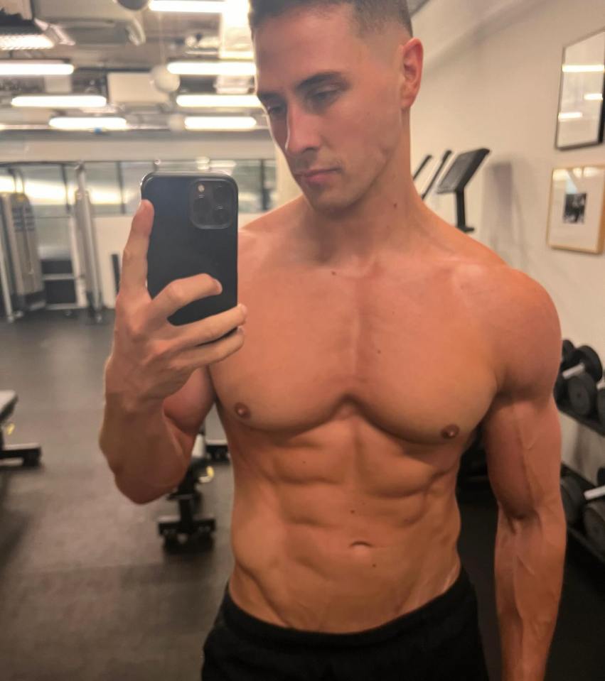 Man taking a selfie in a gym, shirtless.