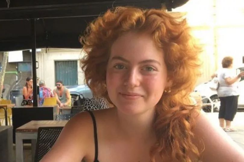 Photo of Sophie Ward, a young woman with curly red hair.