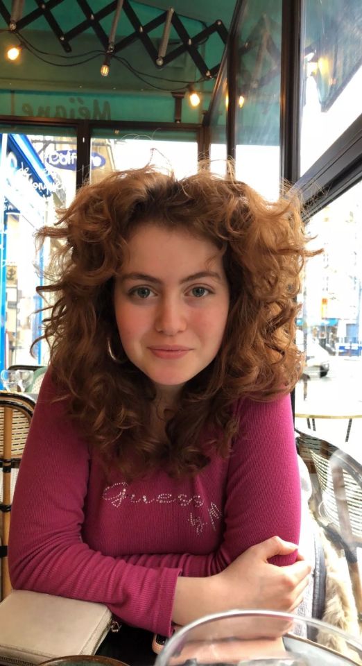 Photo of Sophie Ward, a young woman with curly red hair, wearing a maroon shirt.