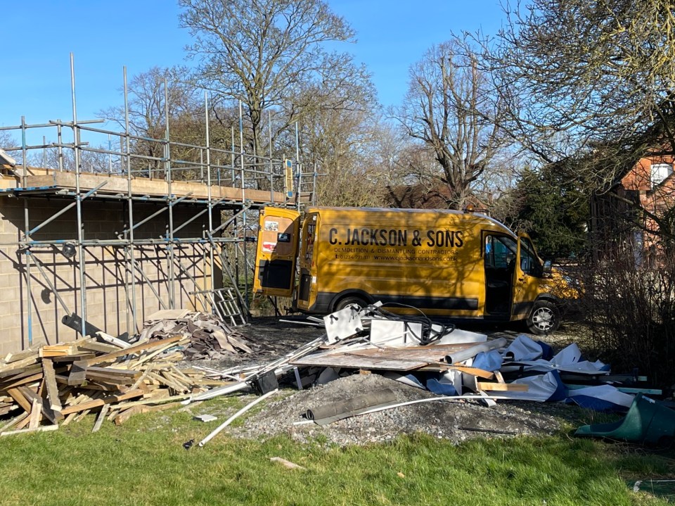 Demolition of a spa complex; debris and a demolition contractor's van are visible.