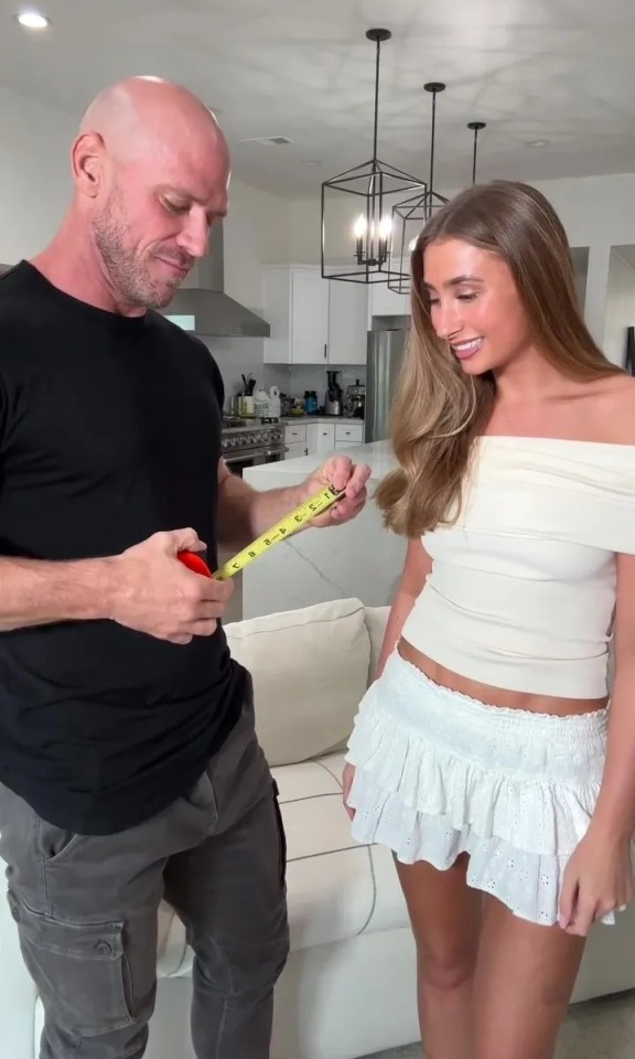A man measuring a woman's waist with a tape measure.