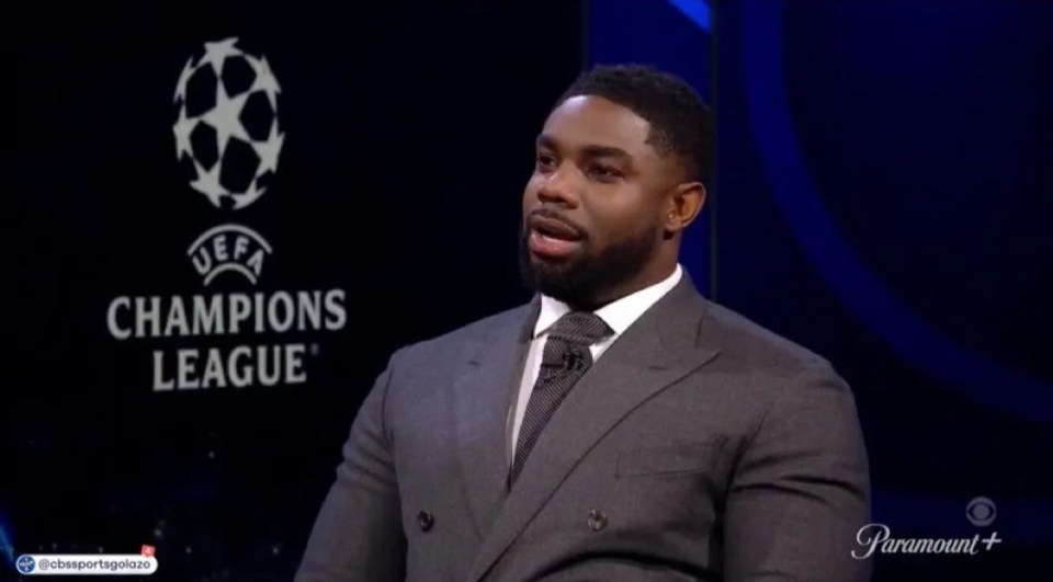 Man in suit speaking on UEFA Champions League panel.