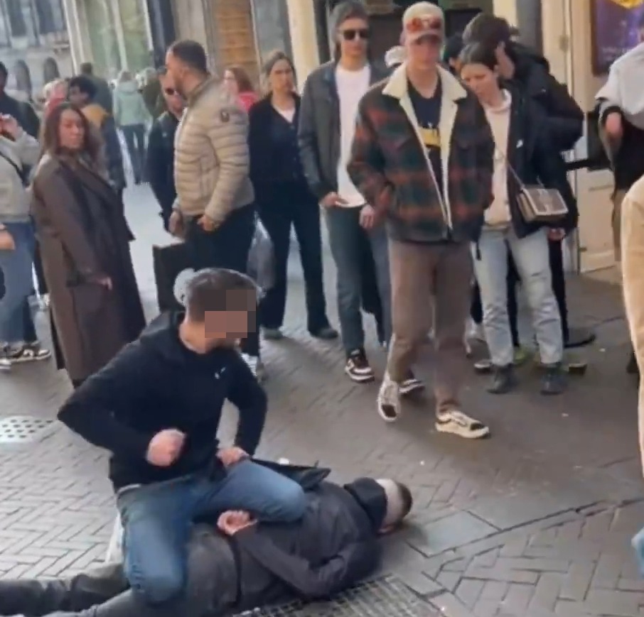 A man subdues a suspect on the ground in Amsterdam.