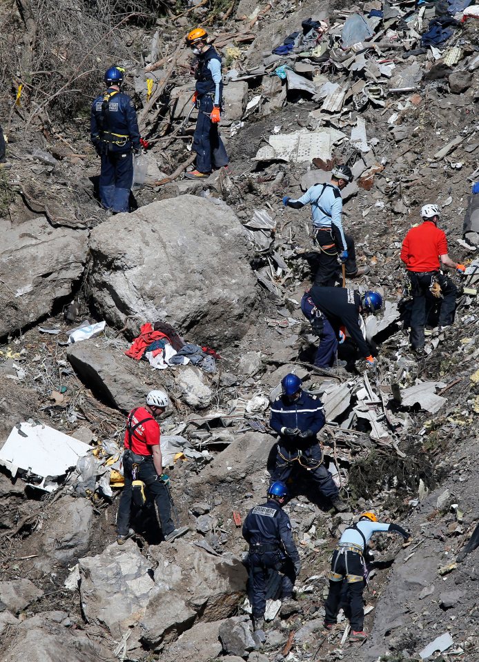 Rescue workers search for victims among the debris of a plane crash.