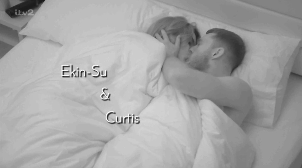 Ekin-Su and Curtis kissing in bed.