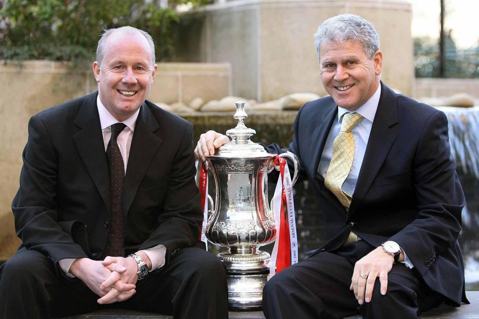 Two men in suits with a trophy.