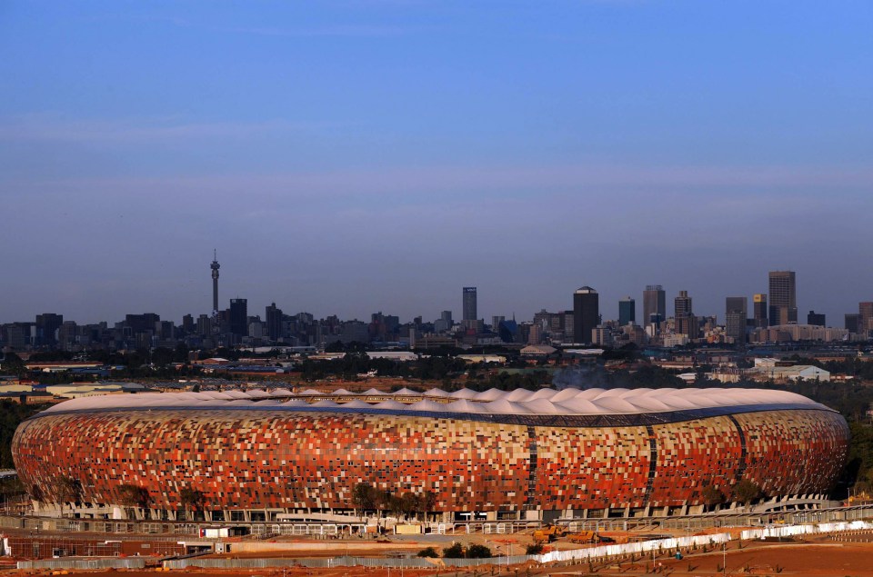 Soccer City Stadium in Johannesburg, South Africa, with the city skyline in the background.