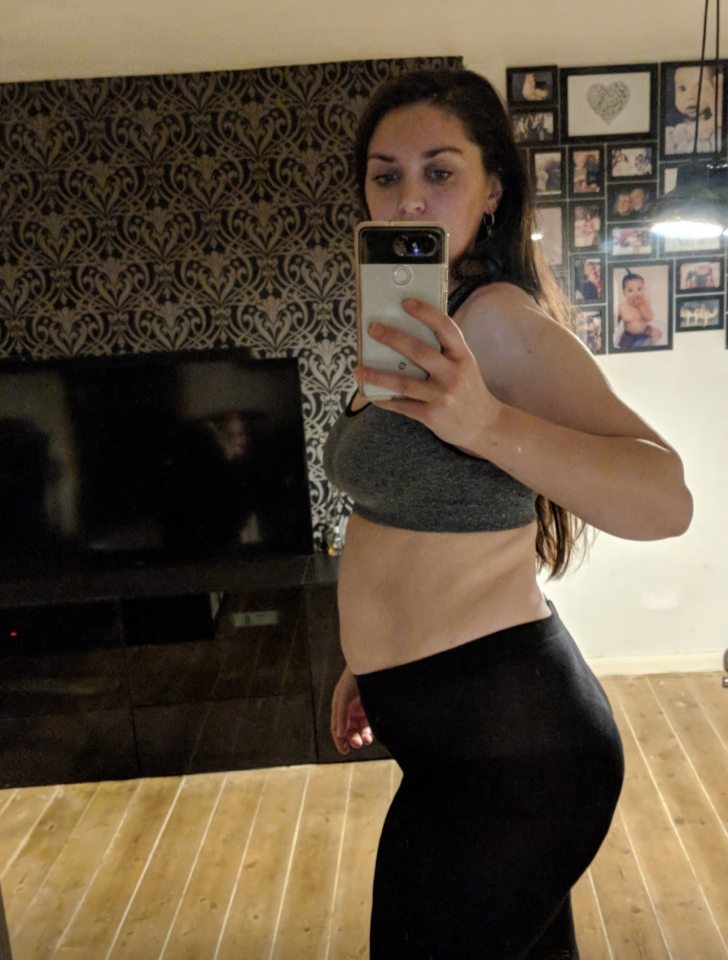 Woman taking a selfie of her body in profile view.
