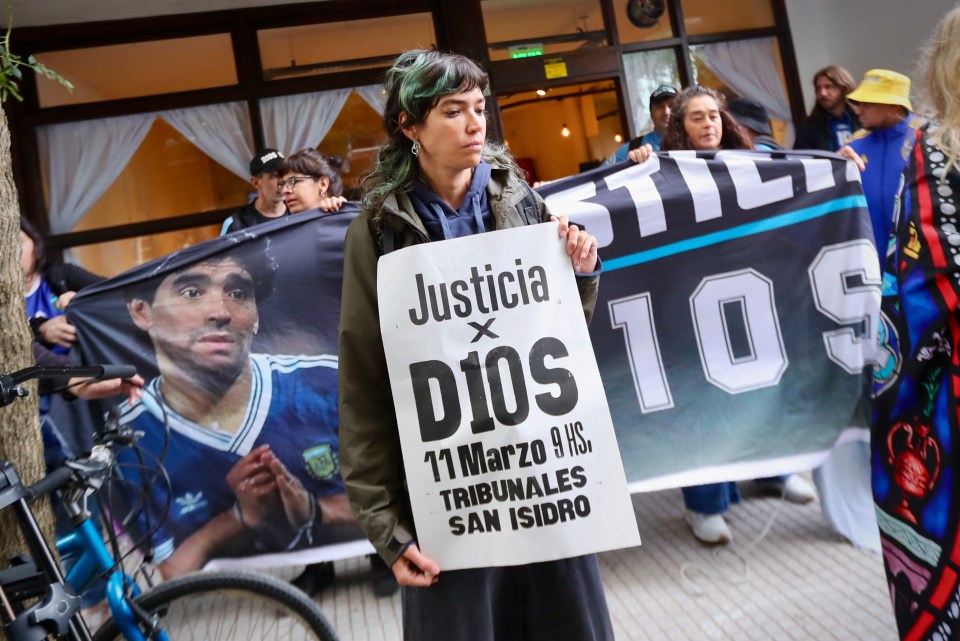 Protestors holding signs and banners in support of Diego Maradona.