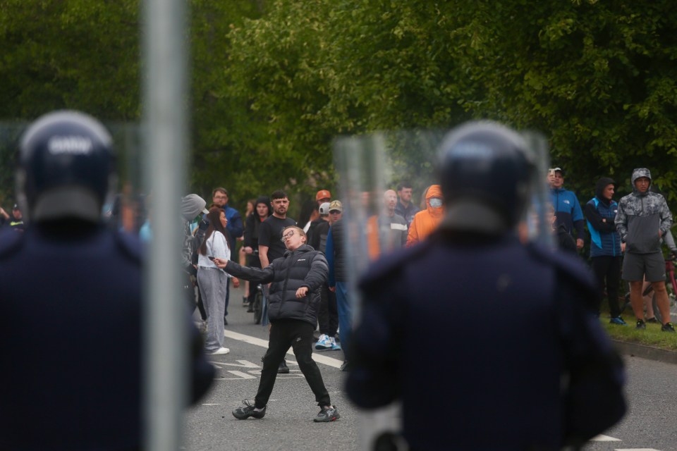 Protestors throwing objects at police during a demonstration against asylum seekers.