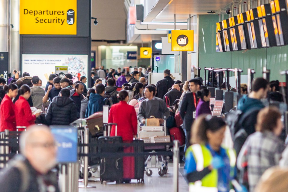 Crowded Heathrow Airport departures security area.