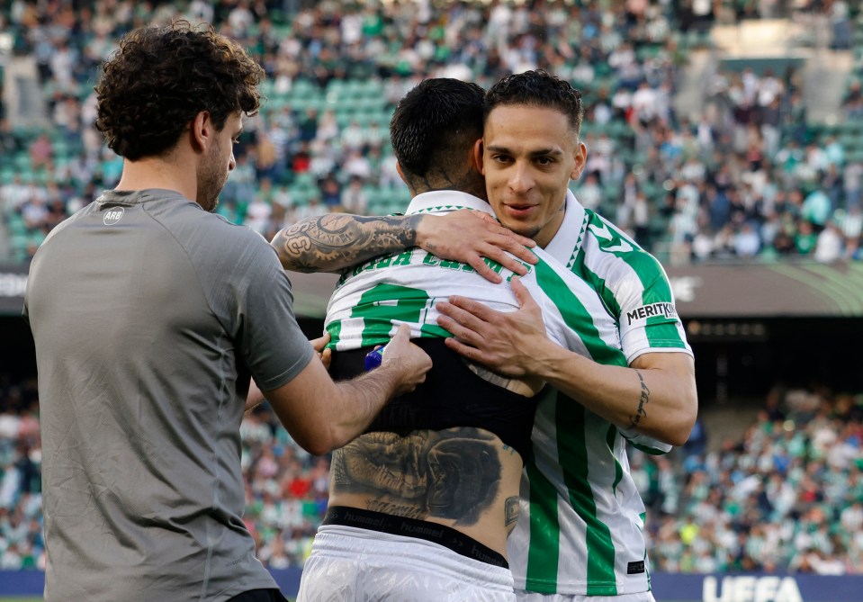 Real Betis players embracing after a match.