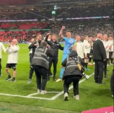 Elliot Anderson celebrating with the Newcastle team on the field.