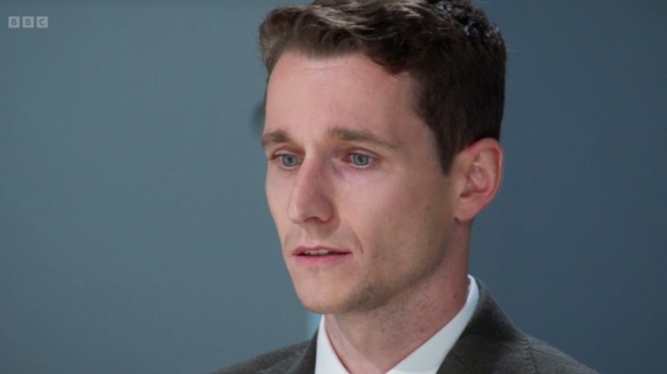 Screenshot of a man in a suit.