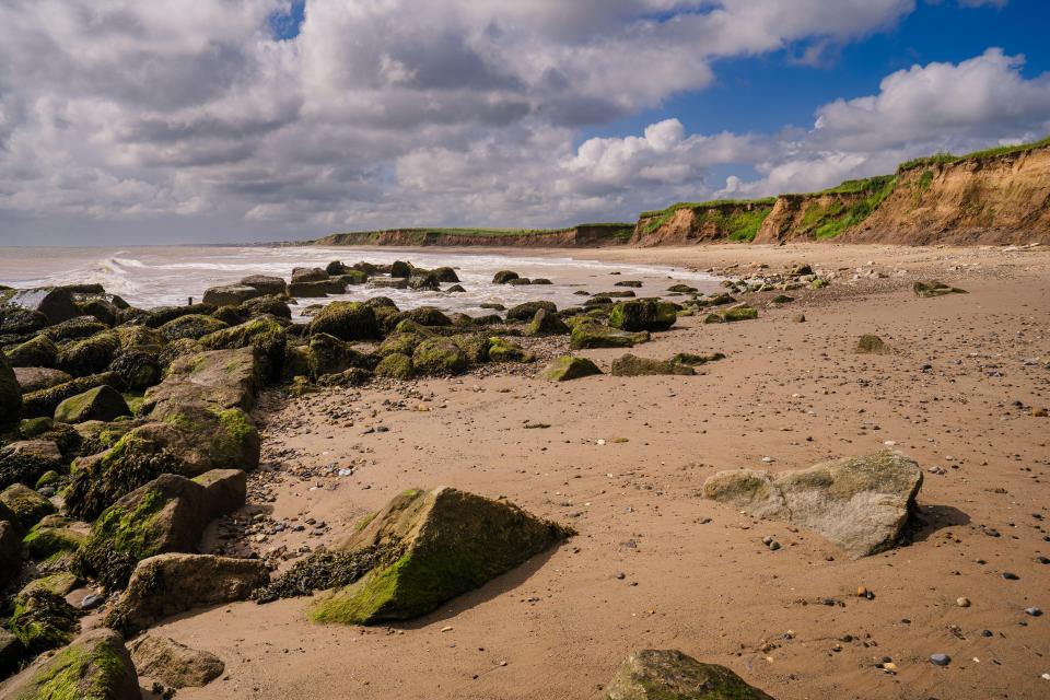 Sandy beach with a cliff face.
