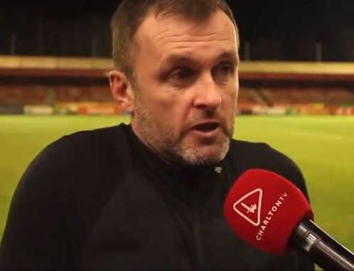 Man being interviewed at a stadium.