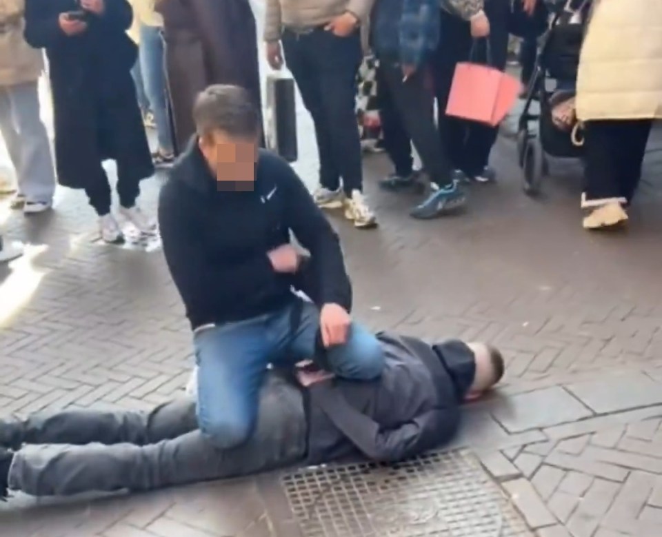 A man subdues a suspect on the ground.