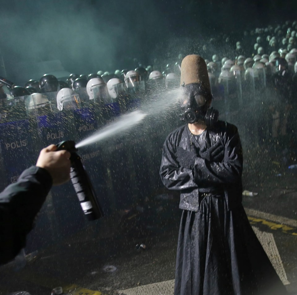 Riot police using pepper spray on a protester during a demonstration in Istanbul.