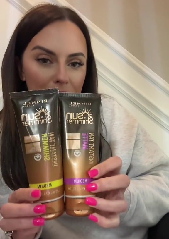 Woman holding two tubes of Rimmel Sun Shimmer instant tan.