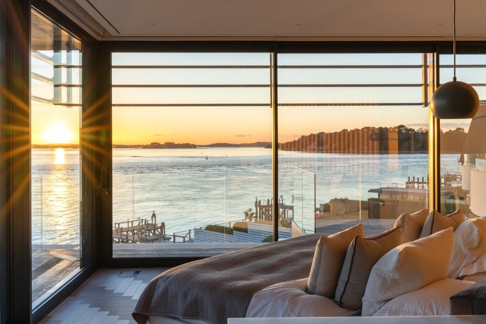 Sunset view from a bedroom with large windows.