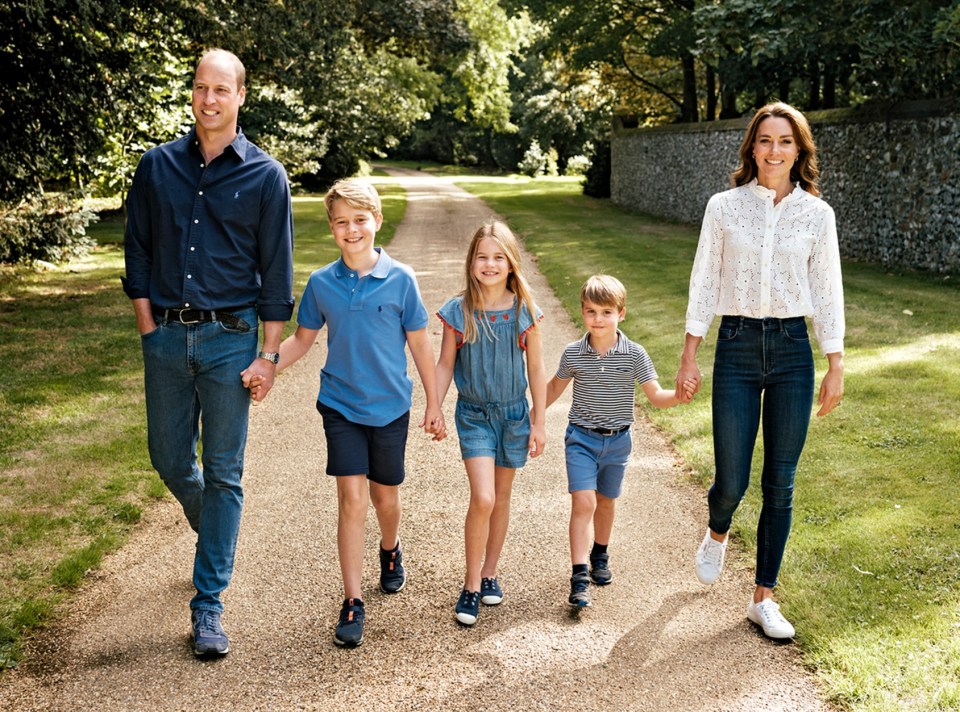 Photograph of Prince William, Princess Catherine, and their three children walking down a path.