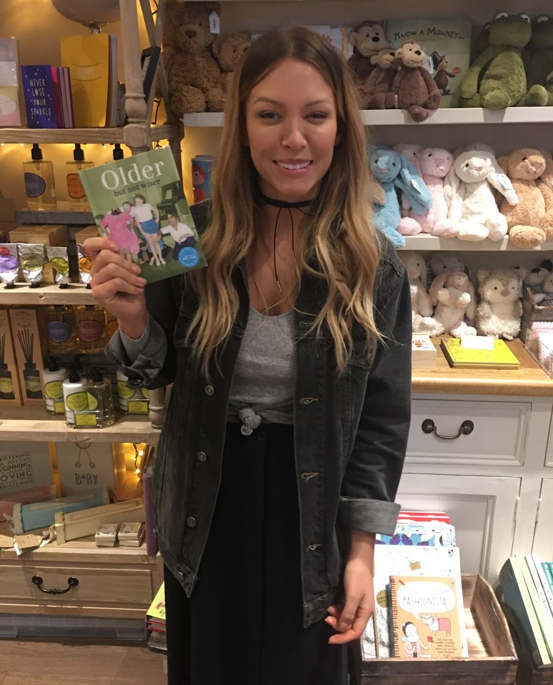Woman holding a book titled "Older but not wiser" in a shop.