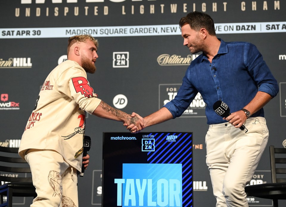 Jake Paul and Eddie Hearn shaking hands at a boxing weigh-in.
