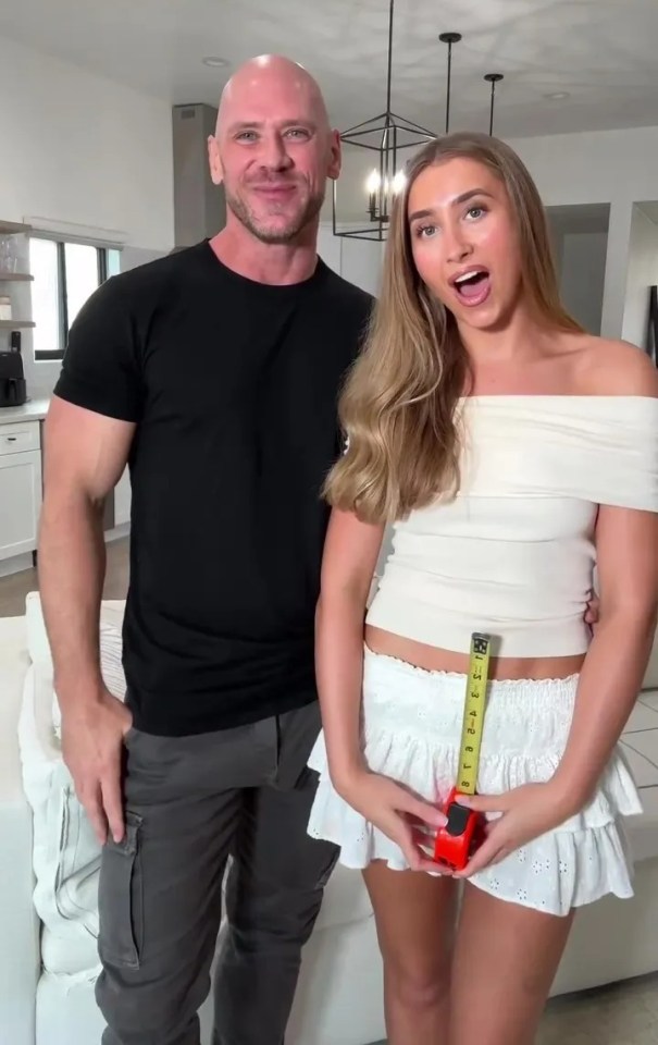 Lily Phillips and a man measuring her waist with a tape measure.