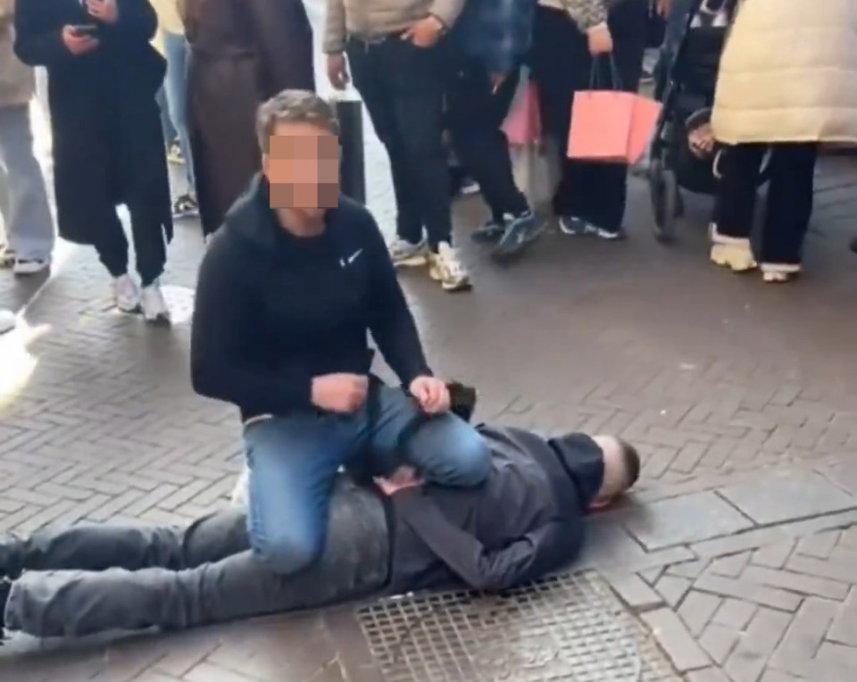 A man subduing a suspect on the ground in Amsterdam.